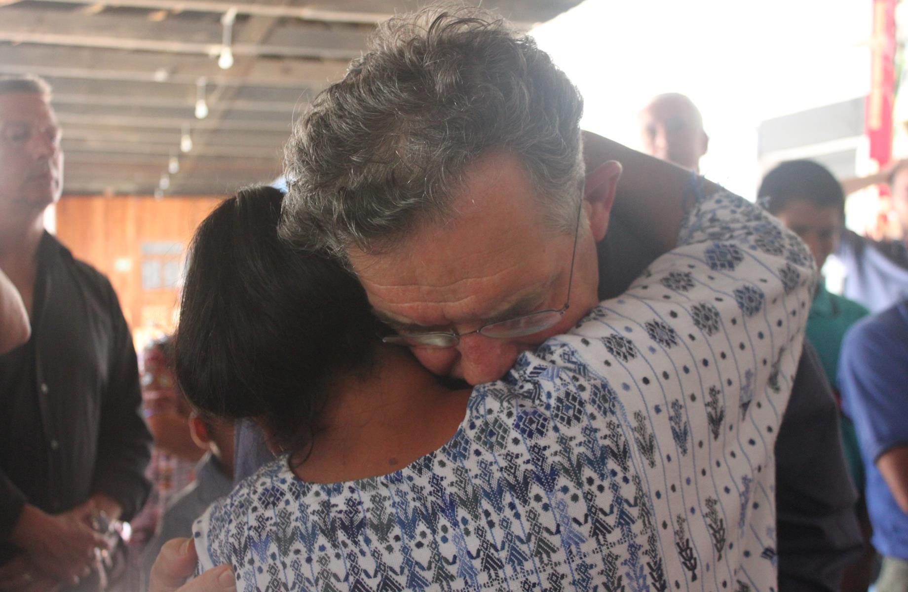 Mgr. Jousten embraces a grieving villager